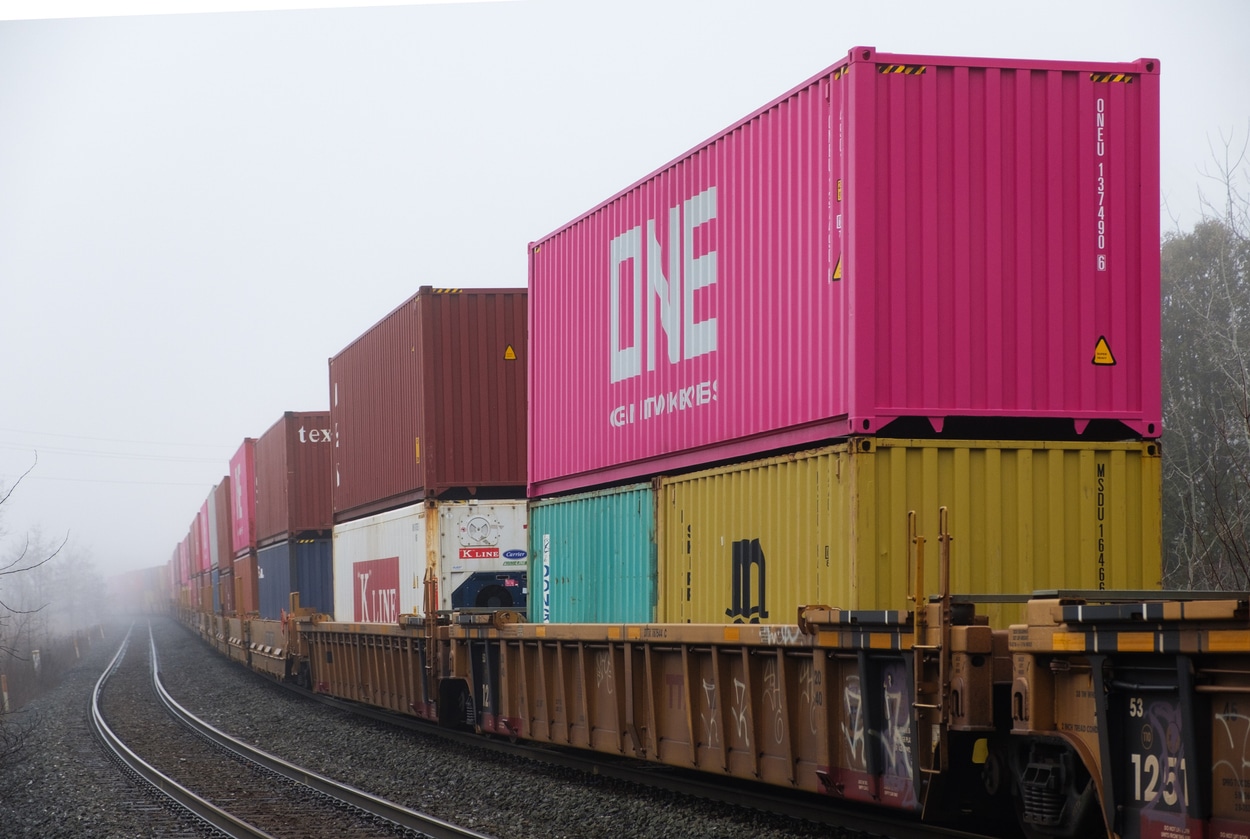 A efficient rail freight train is shipping goods with cargo containers. Rail freight transportation system is busy in Ontario.